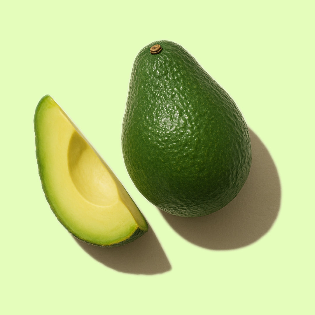 Whole and sliced avocado on a light green background representing LoveLang’s avocado-based damage repair haircare range.
