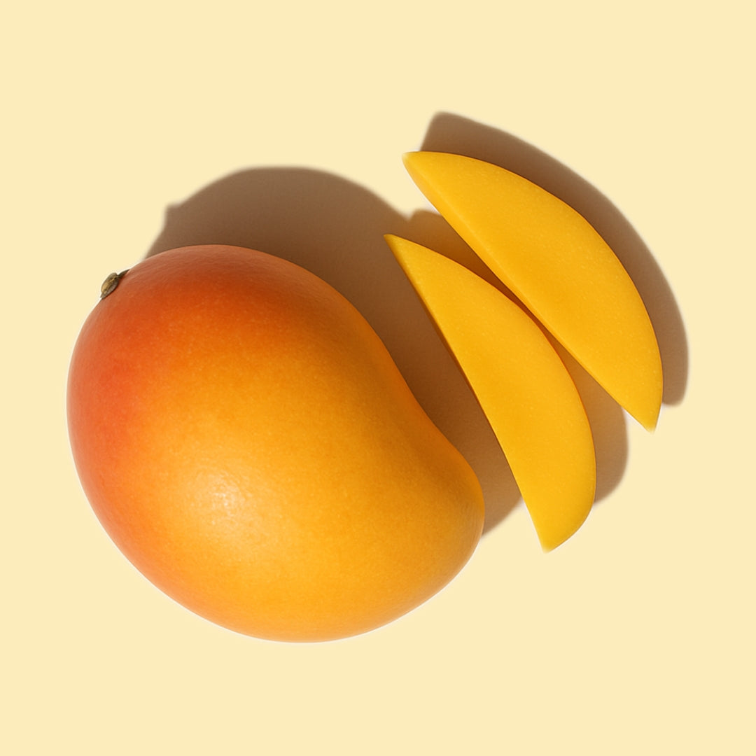 Whole and sliced mango on a soft yellow background representing LoveLang’s mango-based anti-frizz and hydration haircare range.