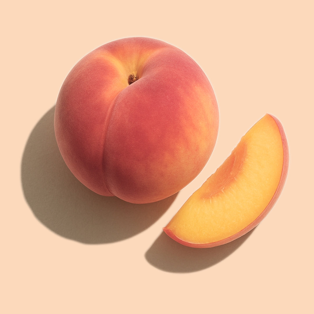 Whole and sliced peach on a soft peach background representing LoveLang’s peach-based hair fall control and volume-boosting range.